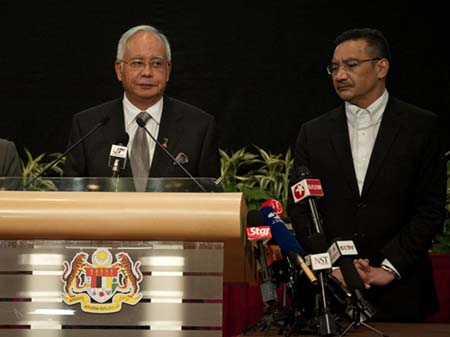 Thủ tướng Malaysia (trái) phát biểu tại Trung tâm Thương mại Thế giới Putra ở thủ đô Kuala Lumpur, Malaysia tối 24/3. Người đứng cạnh ông là Bộ trưởng Quốc phòng kiêm quyền Bộ trưởng Giao thông Hishammuddin Hussein.